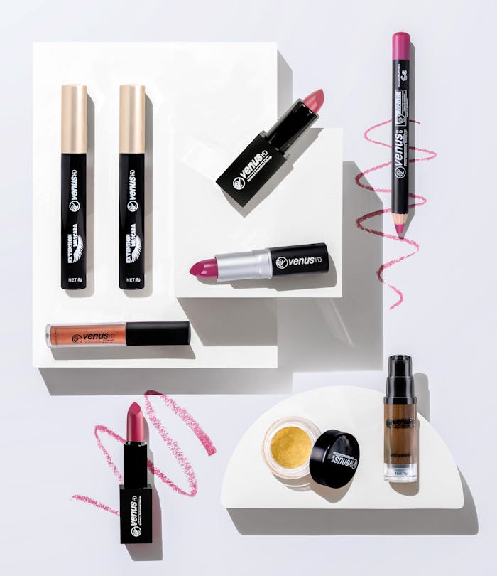 Stylish flat lay of various makeup products including lipstick, eyeliner, and mascara on a white background.